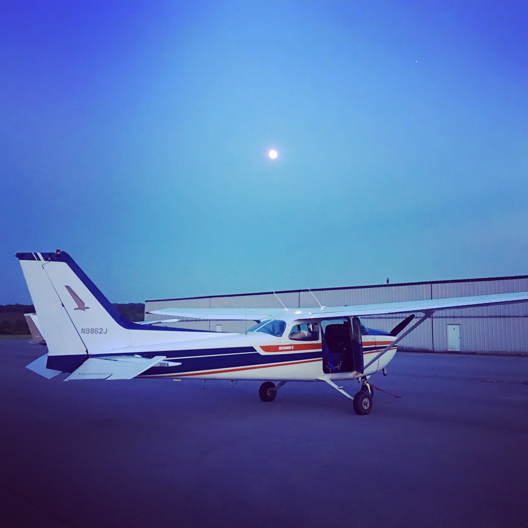 Side view of N9862J outside the hangars at dusk